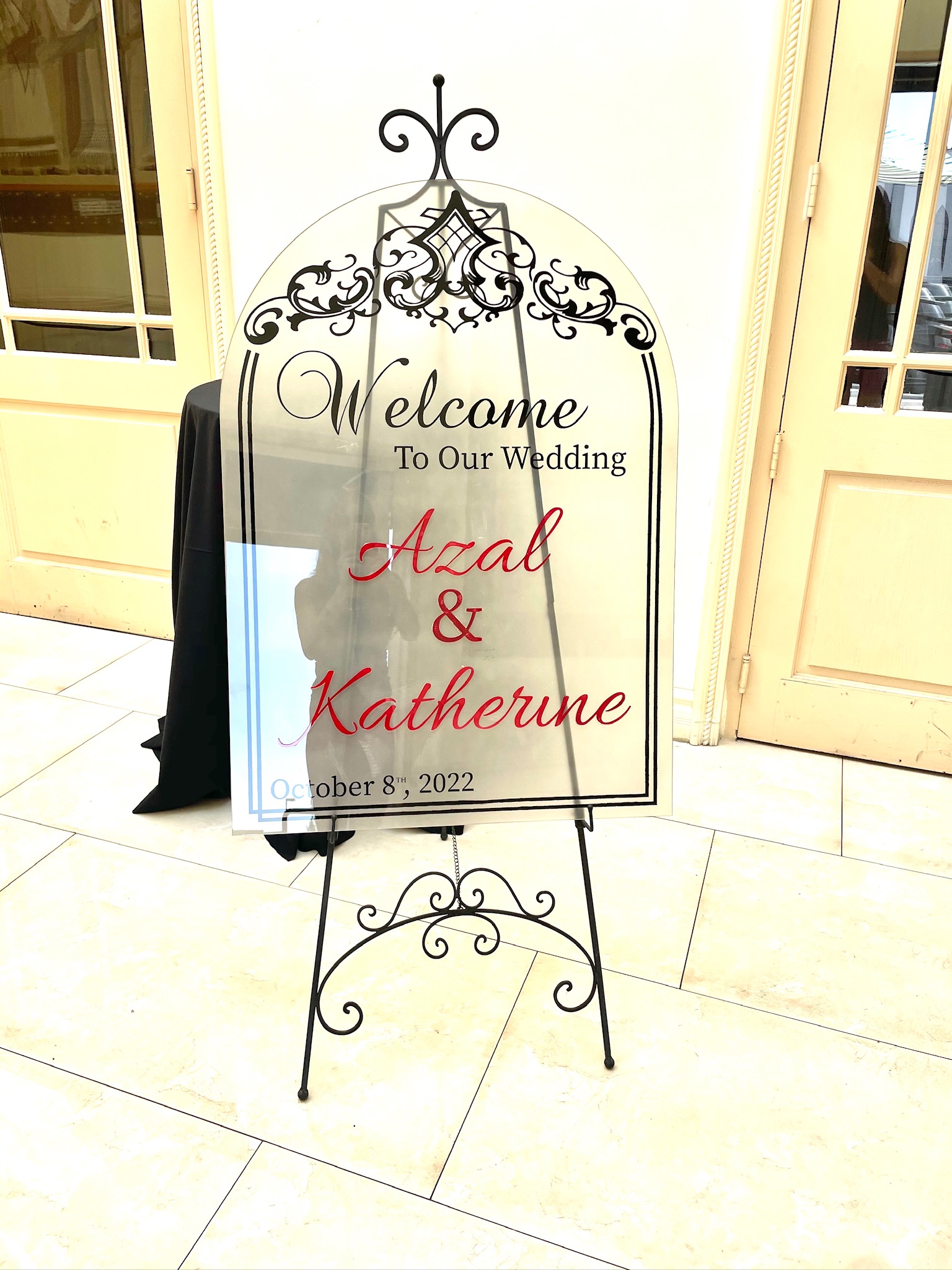 Clear arched wedding welcome sign on an easel
